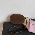 Dettaglio borsa a tracolla in pelle scamosciata marrone con fibbia su superficie in maglia - Marrone