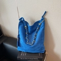Large dark blue suede tote bag with golden metal chain strap on minimalist background - Blue