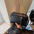 Modern black leather crossbody bag with metal rivets and adjustable strap - Black