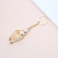 Detailed close-up of a golden beach conch keychain with natural shell and gold metal ring - 11# (Orange Brown Tapered Shell)