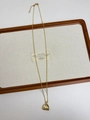 Detalle de collar dorado con colgante de concha plisada y cierre de mosquetón - Collar de bolsa plisada dorada