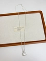 Vista de detalle del collar de plata con colgante de bolsa de la suerte y acabado mate suave - Bolsa de dinero mate plateada