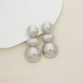 Détail de boucles d'oreilles argentées à trois billes avec texture métallique mate - Argent Mat