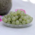 Macro detail of natural Hetian Qingshui jade round beads with smooth polished finish - Harumi Wada / 8mm