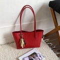 Vibrant red woven tote bag with bohemian beaded pendant charm on white plush rug - Red with Pendant