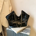 Black quilted tote bag with gold chain handles and large capacity in a sleek vintage style - Black