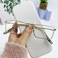 Gafas de sol rectangulares de metal dorado con montura ligera mostradas en mano - Montura Dorada Lente Transparente