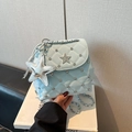 Detail of light blue quilted mini bag featuring silver star charms and rhinestone accents - Blue with Pendant