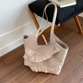 Beige tote bag with ruffle lace detail and shoulder straps shown on a wooden stool - Khaki