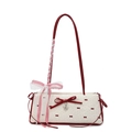 Borsa a spalla chic in tela crema con pois rossi e fiocco su sfondo bianco neutro - Bianco