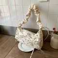 Sac bandoulière en tissu fleuri avec nœuds rouges et bandoulière plissée sur table - Blanc Cassé