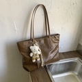 Gros plan d'un sac cabas marron à texture crocodile avec charm ours en peluche - Avec Pendentif / Marron