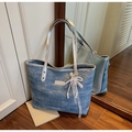 Dettaglio della borsa tote in denim con manici in pelle argento e ciondolo di perle - Blu Denim Con Ciondolo