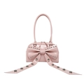 Sac à épaule en cuir verni rose avec grand nœud et rivets argentés sur fond blanc - Rose