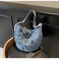 Detail der vintage blau gewaschenen Denim Hobo Bag mit funktioneller Tasche und weicher Textur - Hellblau / Einheitsgröße