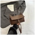 Détail du sac en cuir marron à motif litchi montrant la texture et le fermoir - Marron