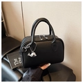 Primer plano detallado de un bolso negro con textura de lichi y colgante de ballena - Negro