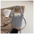 Detalle de bolso tipo cubo azul claro con patrón lychee, forro con cordón blanco y herrajes plata - Azul