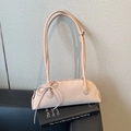 Borsa baguette rosa chiaro in pelle martellata con fiocco decorativo su un libro - Rosa Grande