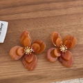 Vue détaillée de boucles d'oreilles fleurs en acrylique ambre et centre doré - Ambre Clair