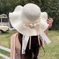 Cream bow straw sun hat with wavy brim and floral decor for beach vacations - Pola Artificial Flower Milky White