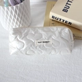 Detail of white heart-quilted pencil case with brand label and smooth zipper texture - Large Heart Off-white