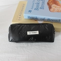 Dettaglio della trousse nera trapuntata con motivo a fiocchi ed etichetta del brand - Fiocchetto Nero