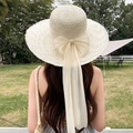Beige wide brim straw sun hat featuring a large bow and long flowing silk ribbons - Large Flowing Ribbons Of White Rice