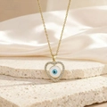 Collier cœur Evil Eye doré avec zircons pavés posé sur une surface en pierre élégante - Style Cœur Bleu Blanc en Zircone Doré (BXL0342-137)