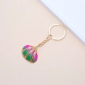 Golden shell keychain with pink and green gradient finish on a cream background - 29# (Pink Radial Scallop)