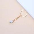 Golden keychain with a natural white spiral seashell pendant on soft beige background - 41# (White Spiral Shape Conch)