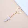 Golden keychain with a natural white conch shell pendant and woven gold thread detail - 43# (White Tapered Pendant with Gold Wire Wrap)