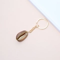 Golden keychain with a natural dark cowrie shell pendant on a pink background - 52# (Dark Brown Beige Gradient Shell)