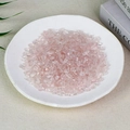 Polished natural pink rose quartz crystal chips displayed in a white ceramic tray - 100g Of High-quality Rose Quartz (5-7mm)
