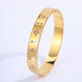 Macro detail of gold titanium bangle with clover motif and sparkling crystal inlays - 18K Gold / Gold Clover Rhinestone Bangle