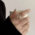 Silver hollow heart ring with twisted rope texture worn on index finger in a minimalist style - Silver Twisted Texture Hollow Heart Style (JZ5114)