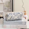 Quilted floral cosmetic bag with blue flower patterns on stacked books in home setting - S / Small Blue Flowers