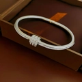 Macro view of silver-tone open bangle featuring three interlocking rings paved with zircons - Silver