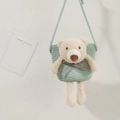 Detail of a light green woven straw bag featuring a cute 3D plush bear with a plaid bow - Green (Bear with Blue Bow)