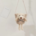 Detail of a beige straw shoulder bag featuring a plush teddy bear and woven strap - Pink (Bear with Blue Bow)