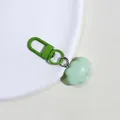 Macro detail of a bright green cloud-shaped resin pendant with a metal alloy keychain - Green