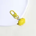 Macro shot of yellow cloud keychain with matte finish alloy lobster clasp on white tray - Yellow