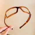 Vue détaillée du serre-tête en résine ambre avec design unique de monture de lunettes - Ambre