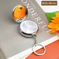 Portable silver metal pill box with mirror and three compartments on a sunflower background - Round 3 Compartments Keychain With Mirror