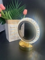 Detail of crystal ring lamp with gold metal base and diamond-cut textured light reflection - Circular Track Style
