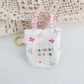 Détail de la mini pochette fleurie avec poignée à carreaux roses et mousqueton jaune - Nœud Coloré