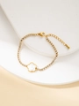 Detail eines Goldarmbands mit Zirkonia-Steinen und einem Perlmutt-Blütenanhänger - Blumenstil (BJGB0088)