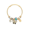 Macro detail of golden spiral bracelet with rhinestone butterfly and glass bead charms - Black