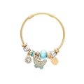 Detailed macro view of butterfly charm and blue glass bead on golden cable bracelet - Blue