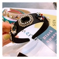 Baroque black satin headband with large gemstones and pearls in hand-held display - Black